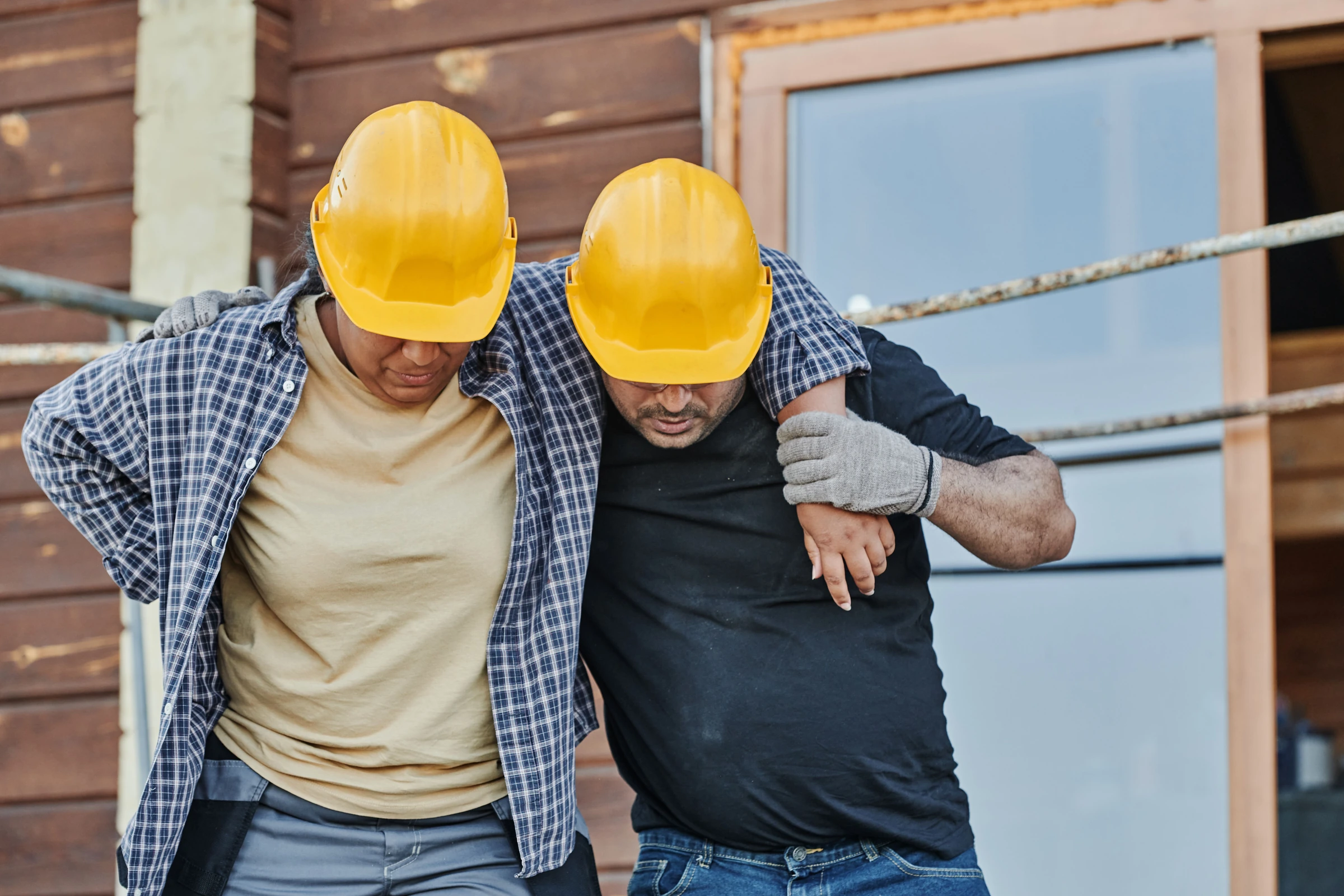 Construction worker supporting an injured colleague
